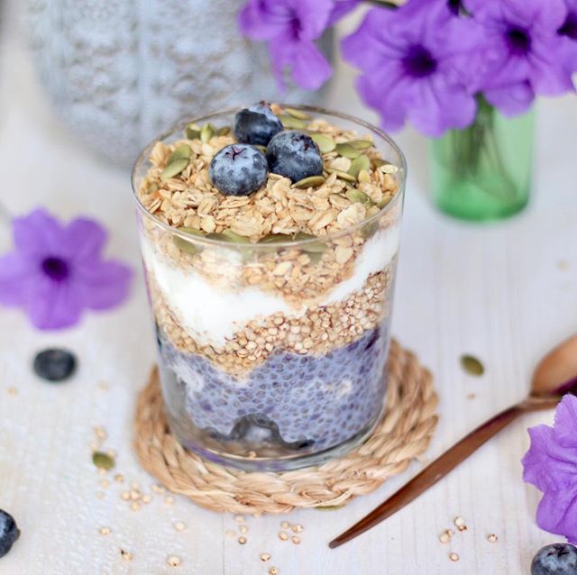 A picture showing a glass showing a blueberry, yoghurt and oat breakfast