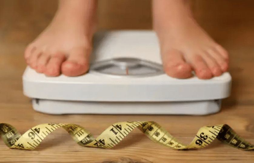 Person standing on scales, with tape measure Low FODMAP & Weight loss