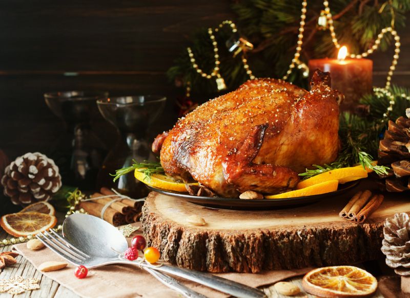 A festive image showing a low FODMAP Christmas turkey surrounded by christmas decorations