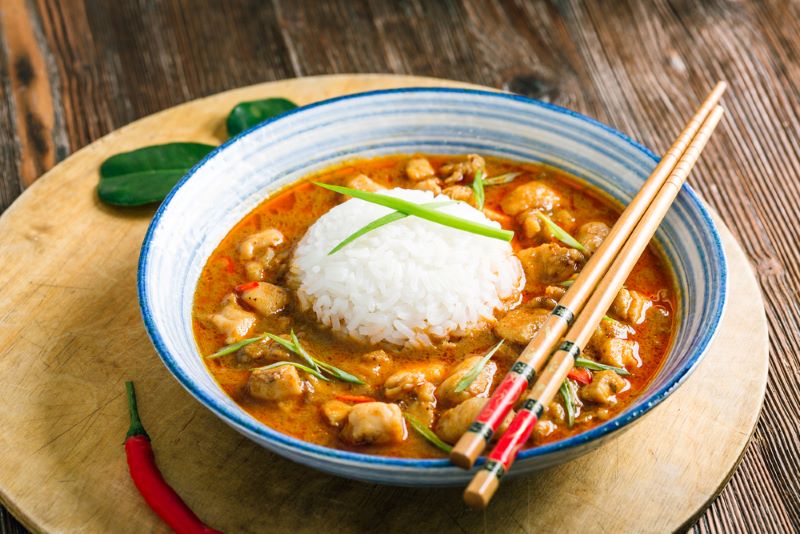 A dish with chopsticks on a tray showing a low FODMAP Thai Red Curry