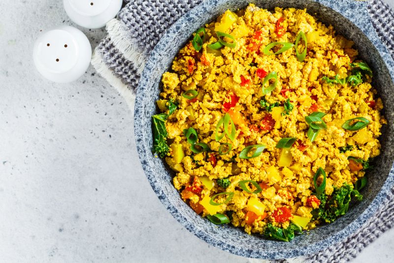 A bowl showing low FODMAP Scrambled Tofu with red peepers and spring onions