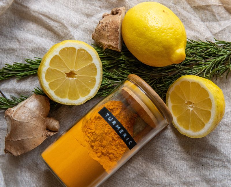 A picture showing ginger, lemons, rosemary and a glass bottle of turmeric. Used to show Essential Pantry items for IBS