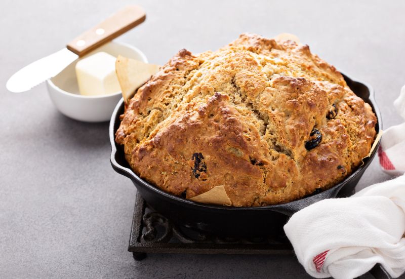 A round baking dish showing a Low FODMAP Irish Soda Bread, with butter