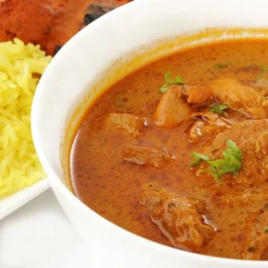 A dish showing low FODMAP Chicken Tikka Massala, with a side dish of rice